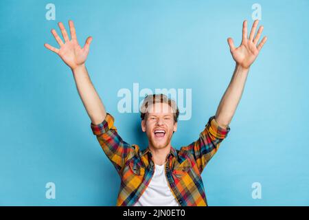 Foto di giovane pazzo ragazzo indossare camicia a quadri in attesa di vendita negozio preferito acquistare nuovi vestiti isolato su sfondo blu Foto Stock