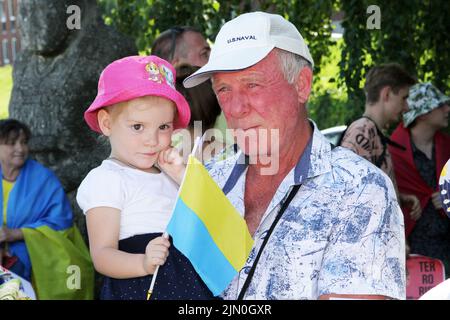 Dnipro, Ucraina. 07th ago 2022. DNIPRO, UCRAINA - 07 AGOSTO 2022 - un uomo anziano tiene una bambina tra le braccia, ha una bandiera a bastone dell'Ucraina durante l'azione a sostegno dei POW Azovstal al Festival Pier per attirare l'attenzione globale sull'attacco terroristico russo a Olenivka, Dnipro, Ucraina orientale. Questa foto non può essere distribuita nella Federazione russa. Credit: Ukrinform/Alamy Live News Foto Stock