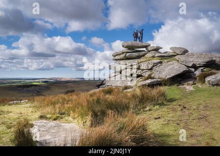 Un gruppo di escursionisti in piedi sulla cima di una pila di roccia a sinistra dopo l'azione glaciale sulla cima di Stowes Hill su Bodmin Moor in Cornovaglia. Foto Stock