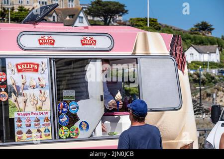 Un villeggiante che acquista un gelato da un furgone Kelly's Ice Cream in Cornwall.in Cornovaglia in Inghilterra nel Regno Unito. Foto Stock