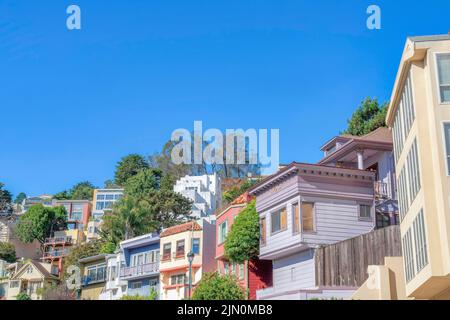 Fila di case in montagna in una vista ad angolo basso a San Francisco, California. Ci sono case colorate sul fronte con balconi e una vista di grandi dimensioni Foto Stock