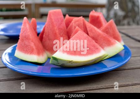 Pezzi di melone su un piatto blu Foto Stock