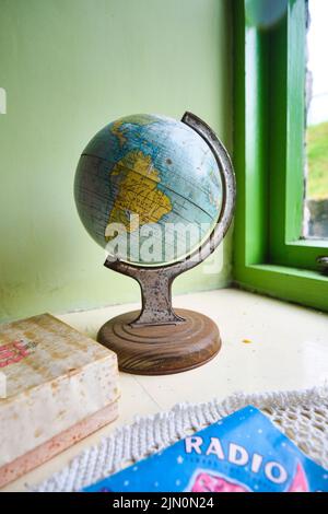 Al piano superiore in una camera da letto per bambini, un piccolo globo metallico, che mostra il Sud America. In una ricreazione di una tipica casa di un lavoratore generico, casa da 1955 a Bl Foto Stock