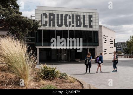 Tre ragazze si trovano di fronte all'ingresso del Crucible Theatre di Sheffield City Centre, Regno Unito, sede dei campionati mondiali di biliardo Foto Stock