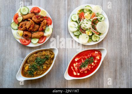 Doncaster, UK - 2019 Mar 21: Pollo tikka masala & pollo Bhuna, pakoras e insalata verde da Goa Indian Foto Stock