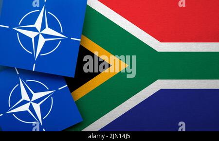 LONDRA, Regno Unito - Agosto 2022: Logo dell'alleanza militare della NATO del Trattato Atlantico Nord su una bandiera del Sud Africa Foto Stock