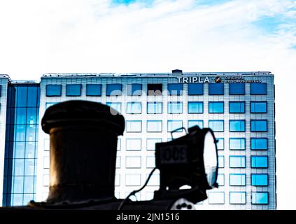 Originale Sokos Hotel Tripla a Helsinki, Finlandia. In primo piano, il faro di una locomotiva a vapore che corre nel cantiere ferroviario Pasila. Foto Stock