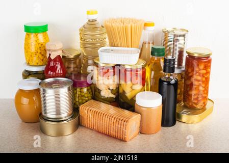 Cibo di sopravvivenza di emergenza impostato su tavolo da cucina bianco Foto Stock