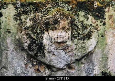 Headstone con la faccia di Angel ricoperta di Moss Foto Stock