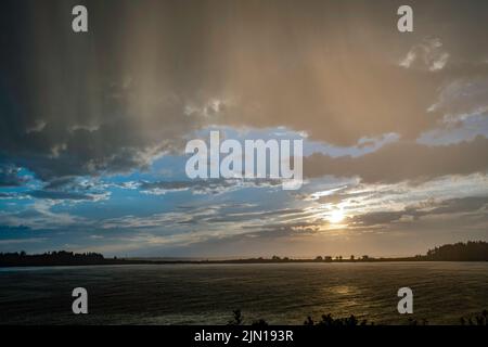 Luglio 8, 2022. 7:45:50 pm. Pioggia squall, cielo blu e sole, tutti insieme. Vista dall'isola di Barnes. Baia di casco, Maine. Serie Rain Storm. Foto Stock