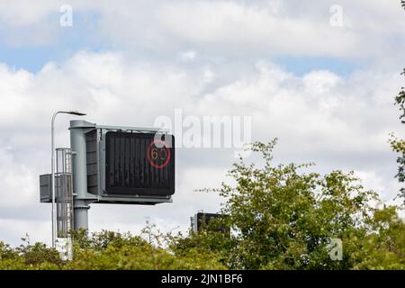 segnale gantry autostrada uk con limite di velocità imposto 60 mph, miglia all'ora, spazio di copia Foto Stock