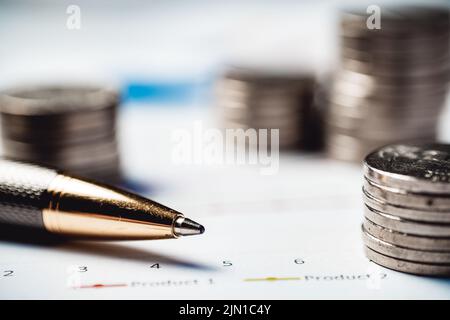 Le monete giacciono su un tavolo con una penna e documenti. Concetto di denaro e finanza Foto Stock