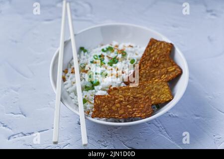 Tempeh fritto con riso in una ciotola, cibo vegetariano Foto Stock