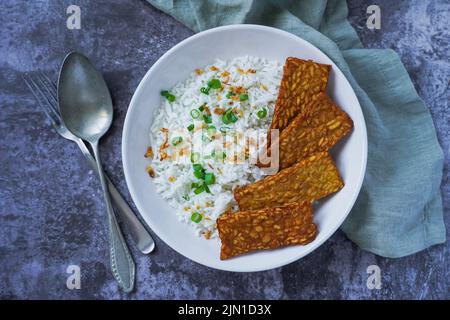 Tempeh fritto con riso in una ciotola, cibo vegetariano Foto Stock