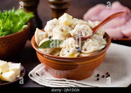 Gnocchi ripieni di carne in ciotola, Pelmeni russo, cibo fatto in casa. Avvolto in pasta di carne tritata, simile ai tortellini italiani Foto Stock