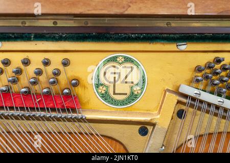 L'interno del pianoforte è privo di coperchio. Corde, martelli e altre parti di uno strumento musicale sono visibili. Messa a punto e riparazione di uno strum musicale Foto Stock