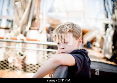 Boy di otto anni che esplora la barca a vela al Maritime Museum di San Diego Foto Stock