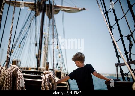 Boy di otto anni che esplora la barca a vela al Maritime Museum di San Diego Foto Stock