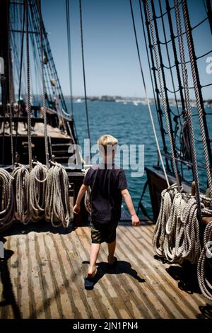 Boy di otto anni che esplora la barca a vela al Maritime Museum di San Diego Foto Stock