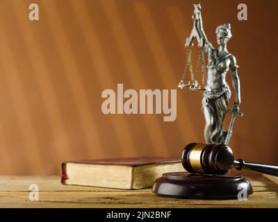 Processo equo e giusto. Su uno sfondo beige c'è un libro chiuso - la Bibbia, una statuetta in bronzo della dea della giustizia Themis e il gavel in legno di un giudice Foto Stock