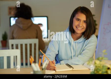 Ritratto di studente scuola sorridente scrittura e schizzo in pianificatore Foto Stock