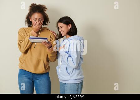 Studentessa eccitata che copre la bocca quando l'apertura della lettera di accettazione dall'università Foto Stock