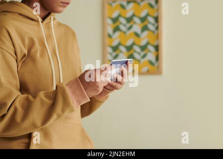 Immagine ritagliata di una scolgirl seria paura di aprire la lettera da università o college Foto Stock
