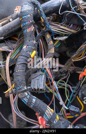 Un fascio di cavi o fili elettrici è fortemente mescolato l'uno con l'altro. Resti di fili di colori diversi. Cavi vecchi collegati l'uno all'altro Foto Stock
