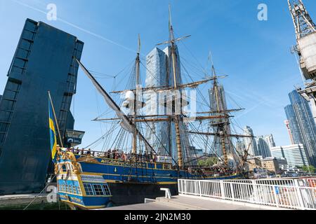 Nave alta svedese Goteborg (Götheborg di Svezia) che passa sotto un ponte blu sopraelevato per ormeggi a Thames Quay nel molo sud di Canary Wharf. Foto Stock