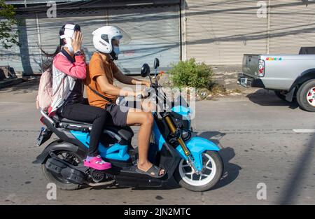 SAMUT PRAKAN, THAILANDIA, 12 2022 MAGGIO, la coppia corre in moto per strada con testa di donna bandaged. Foto Stock