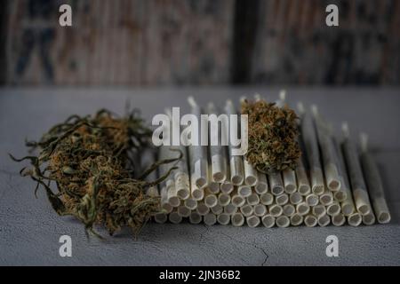 Giunti in carta marijuana su pavimento in cemento con fondo in legno Foto Stock