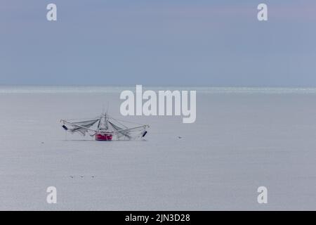 Imbarcazione commerciale per la pesca dei gamberetti con reti utilizzate alla luce del mattino presto. Ampio spazio per la copia, se necessario. Foto Stock