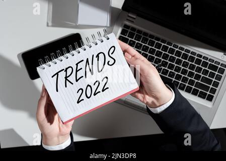 Didascalia testo Presentazione tendenze 2022. Idea di business anno prossimo prevalente tendenza ampiamente discusso Online Businesswoman Holding notebook over Desk Foto Stock