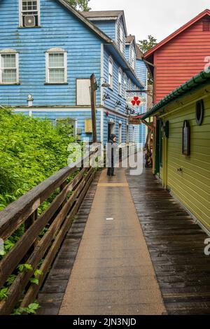 Ketchikan, AK - 10 Giugno 2022: Turista in pioggia sul lungomare di Creek Street in Ketchikan Alaska Foto Stock