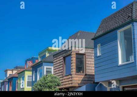 Vista laterale di abitazioni suburbane adiacenti con tegole in asfalto composito a San Francisco, CA. Ci sono due case sulla destra con lati in legno al Foto Stock