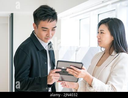Colleghi aziendali che hanno una discussione mentre guardano i tablet digitali. Ambiente di lavoro o ufficio. Foto Stock