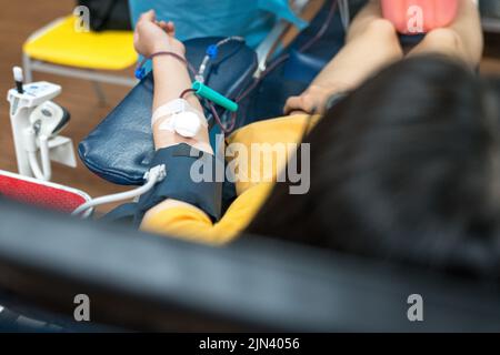 Donatore di sangue giacente sul letto dell'ospedale che dona sangue. Foto Stock