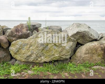 Barriera di grandi pietre sulla riva del mare. Protezione dalle onde. Pietre irregolari. Riva del mare. Vista Foto Stock