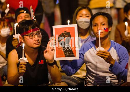 Chiang mai, Thailandia, 08/08/2022, un attivista tiene una candela illuminata e solleva tre saluti dito durante l'anniversario della '8888 rivolta' alla porta di Tha Phae a Chiang mai. Il 8th agosto Myanmar ha commemorato il 34th anniversario della "rivolta del 8888", nota anche come rivolta del potere popolare, Che ha raggiunto il picco il 08 agosto 1988, è stata una serie di manifestazioni, marce e proteste a livello nazionale che hanno iniziato come movimento studentesco a Yangon prima di diffondersi nel resto del paese. Le manifestazioni sono state tenute contro il regime del Partito del programma socialista birmano (BSPP), allora al potere, una stat monopartitica Foto Stock