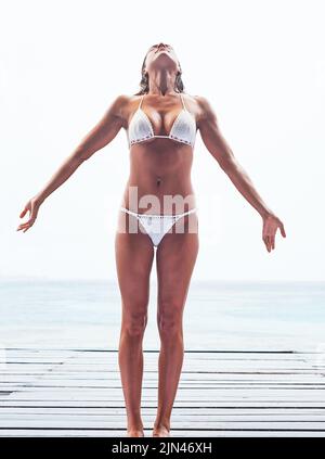 L'estate è qui e sono pronta per essa. Una bella giovane donna che posa nella sua bikini sulla spiaggia. Foto Stock