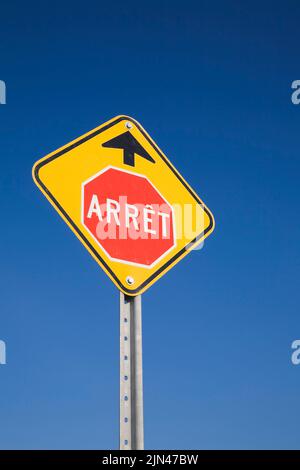 Segnale di stop in lingua francese con segnale di avvertimento davanti su sfondo blu, Quebec, Canada. Foto Stock