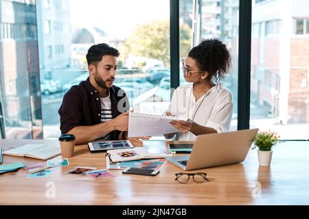 Questo è ciò che penso: Due giovani uomini d'affari che si siedono insieme in ufficio e leggono documenti durante una riunione. Foto Stock