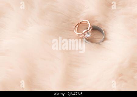 Due vite, un amore, due anelli di nozze su uno sfondo furry. Foto Stock