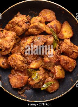 primo piano di curry di pollo rosso, piatto temprato di cremoso ma piccante, aromatico e mescolato con patate, preso direttamente dall'alto Foto Stock