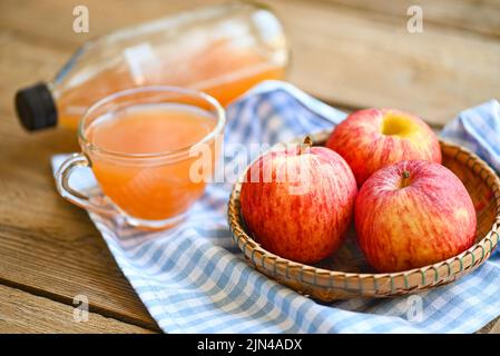 aceto di sidro di mele rimedi naturali e cure per le condizioni di salute comuni, aceto di sidro di mele crudo e non filtrato in vetro con frutta di mela Foto Stock