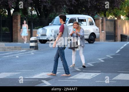 Londra, Regno Unito, 8th agosto, 2022. I tifosi dei Beatles posano per le foto sul crossing utilizzato dalla band 53 anni fa fino al giorno che è stato utilizzato per una fotografia per la copertina dell'album 'Abbey Road'. La mattina del 8th agosto 1969 il fotografo Iain Macmillan ha scattato solo sei foto del gruppo che ha attraversato la traversata della zebra che si trova vicino allo studio di registrazione. Credit: Undicesima ora Fotografia/Alamy Live News Foto Stock