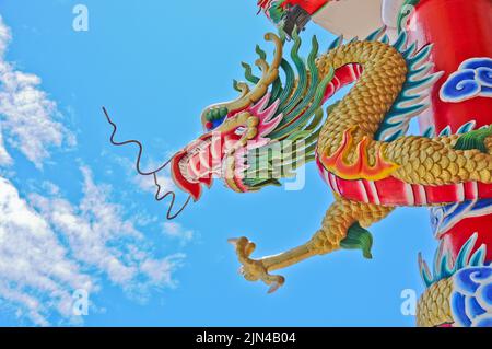 Golden Flying maestosa statua del drago asiatico cinese con cielo blu in giornata di sole Foto Stock