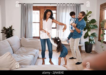 Fare la loro danza felice. Una famiglia di quattro ballare insieme a casa. Foto Stock