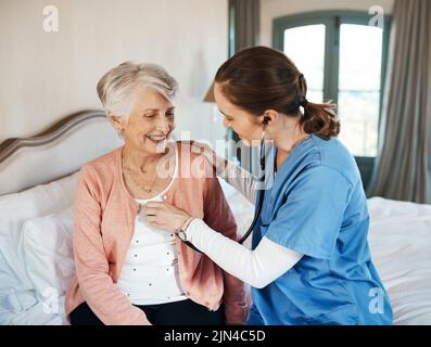 Il suo medico preferito fa le chiamate della casa. Una donna anziana che ottiene un controllo da una giovane infermiera in una casa di pensione. Foto Stock