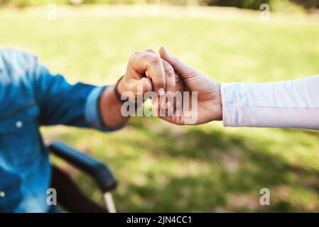 Mal tenere la mano attraverso di esso tutto. Una donna irriconoscibile che tiene un uomo anziano mani. Foto Stock